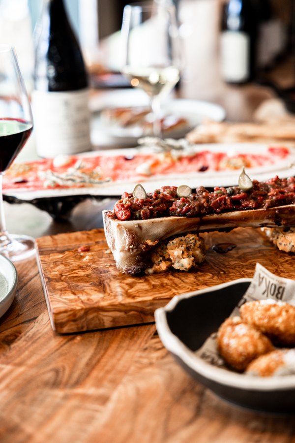 Mesa con platos y vino en BOKA Ibiza